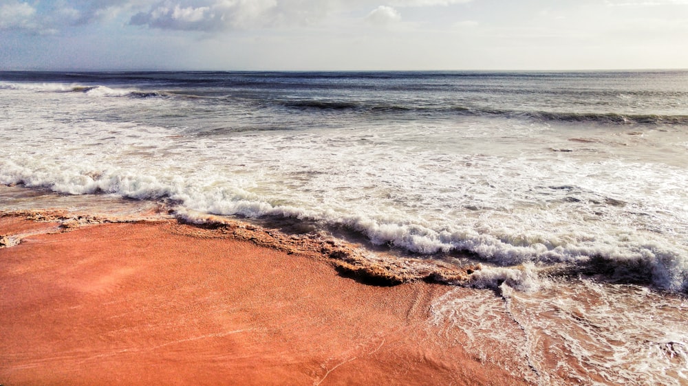 ocean waves crashing on shore during daytime