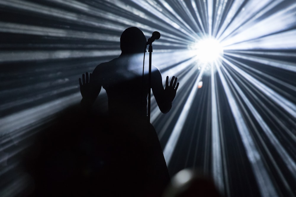 silhouette of man holding microphone