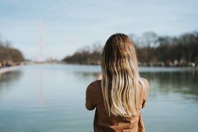 woman in brown long sleeve shirt standing near body of water during daytime lincoln memorial zoom background