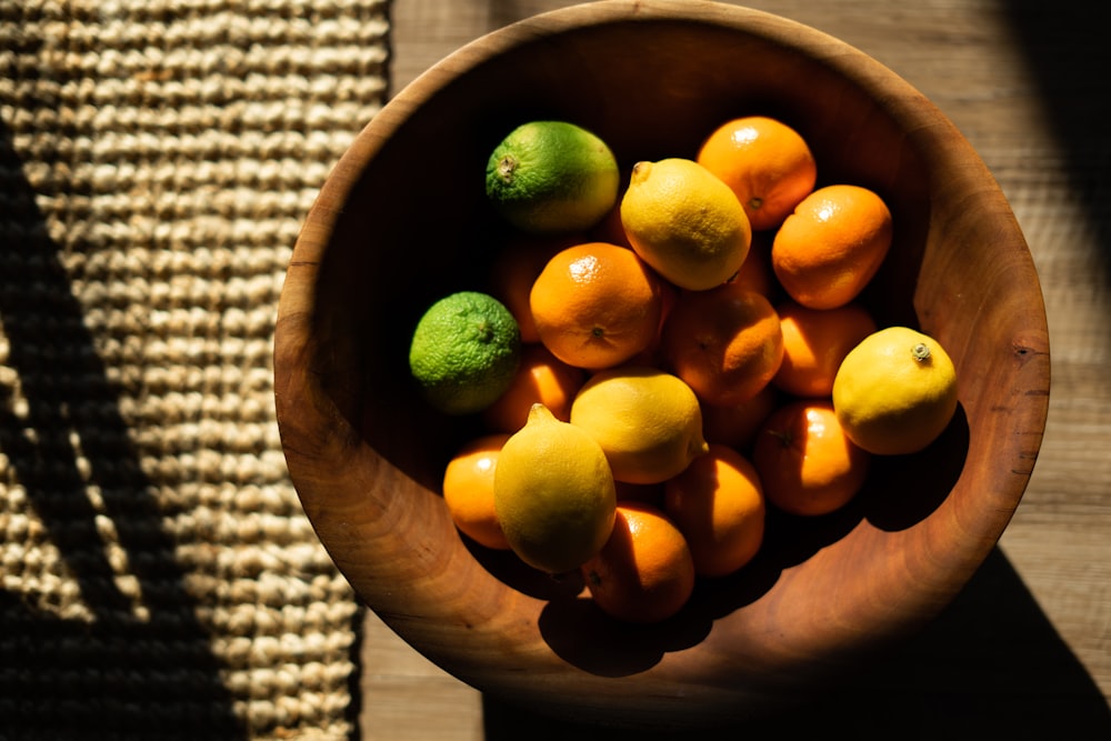 yellow citrus fruit on brown wooden bowl