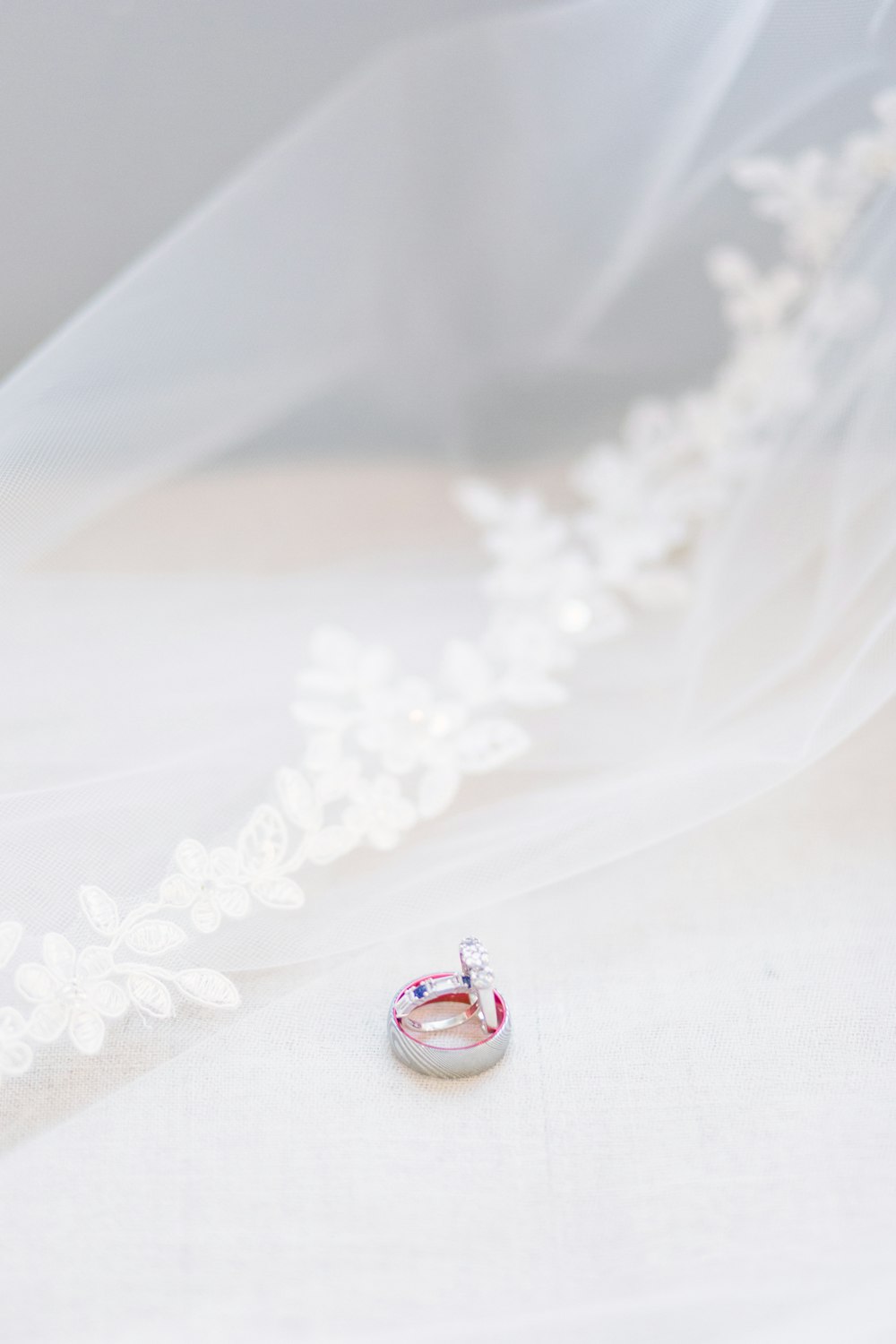 Anillo de plata y diamantes rojos sobre textil blanco