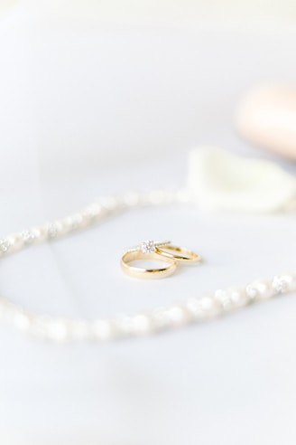 gold diamond ring on white textile