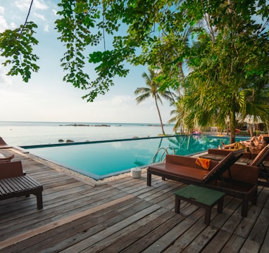 brown wooden table and chairs on brown wooden deck near body of water during daytime