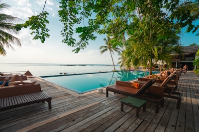 brown wooden table and chairs on brown wooden deck near body of water during daytime