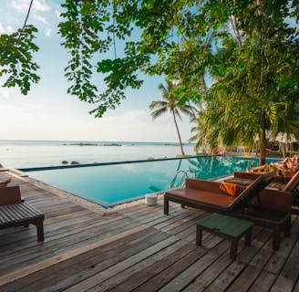 brown wooden table and chairs on brown wooden deck near body of water during daytime