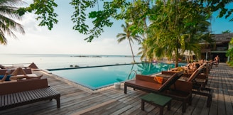 brown wooden table and chairs on brown wooden deck near body of water during daytime