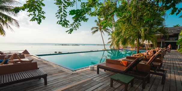 brown wooden table and chairs on brown wooden deck near body of water during daytime