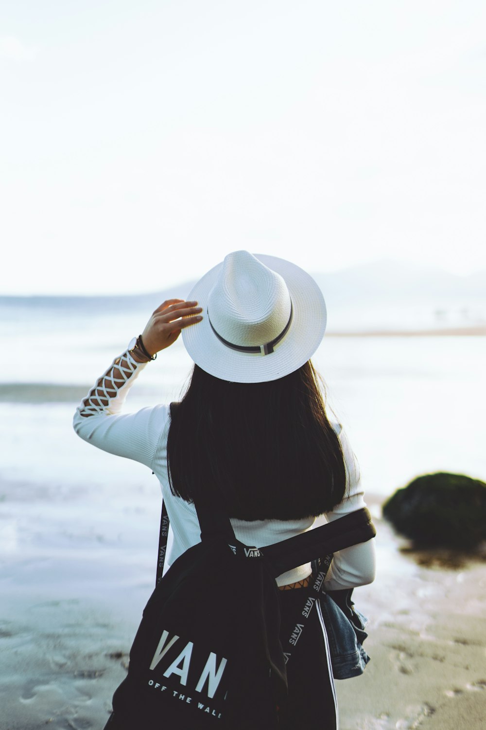 woman in white sun hat and black long sleeve shirt sitting on chair