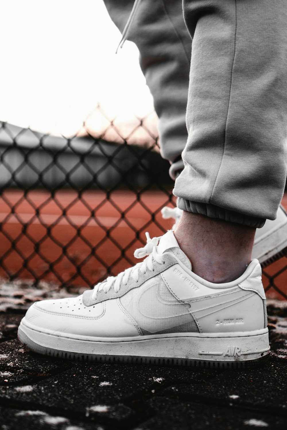 person in gray pants wearing white nike air force 1 low