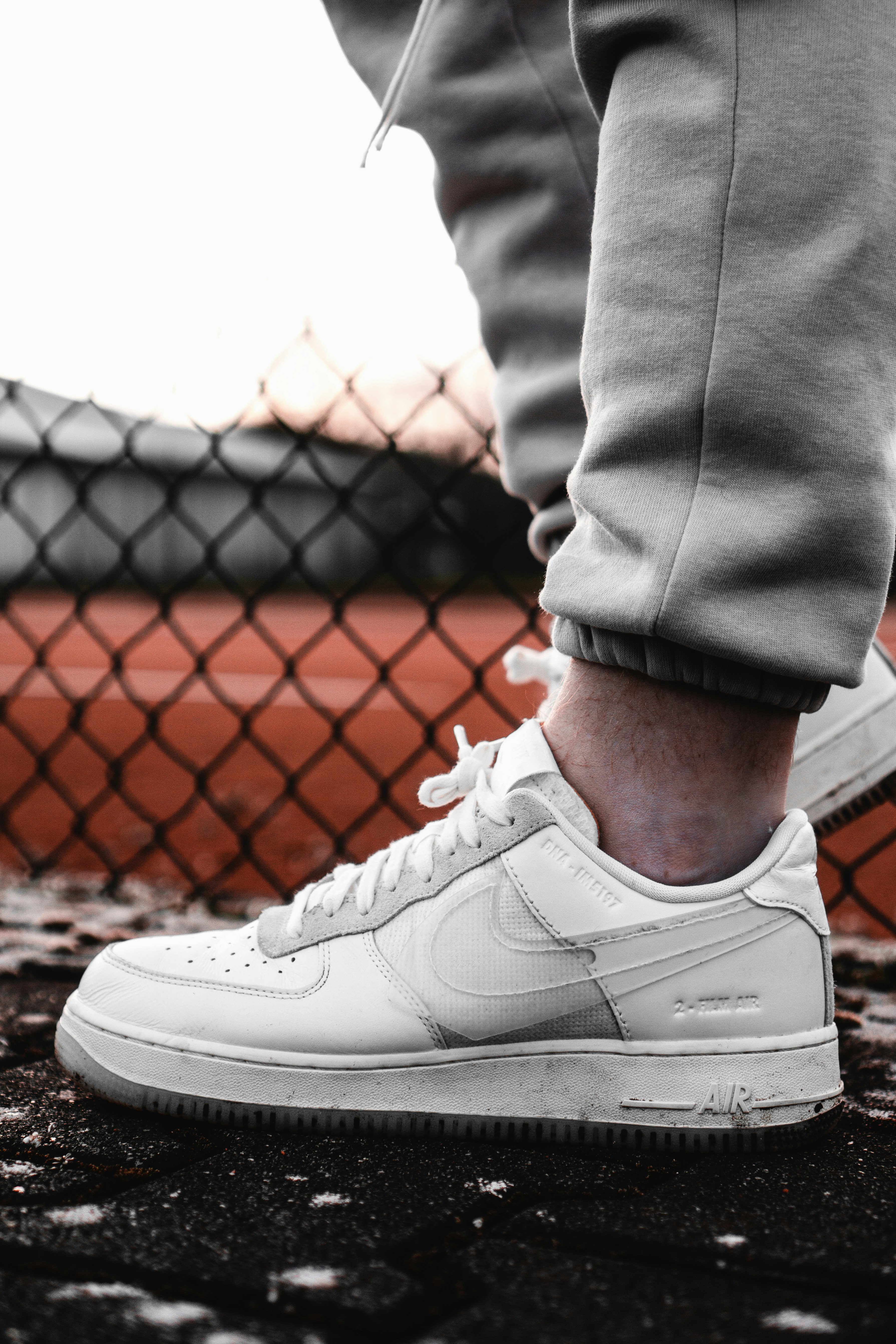 person in gray pants wearing white nike air force 1 low