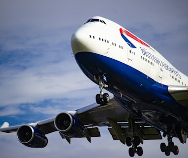 white and blue airplane under white clouds during daytime