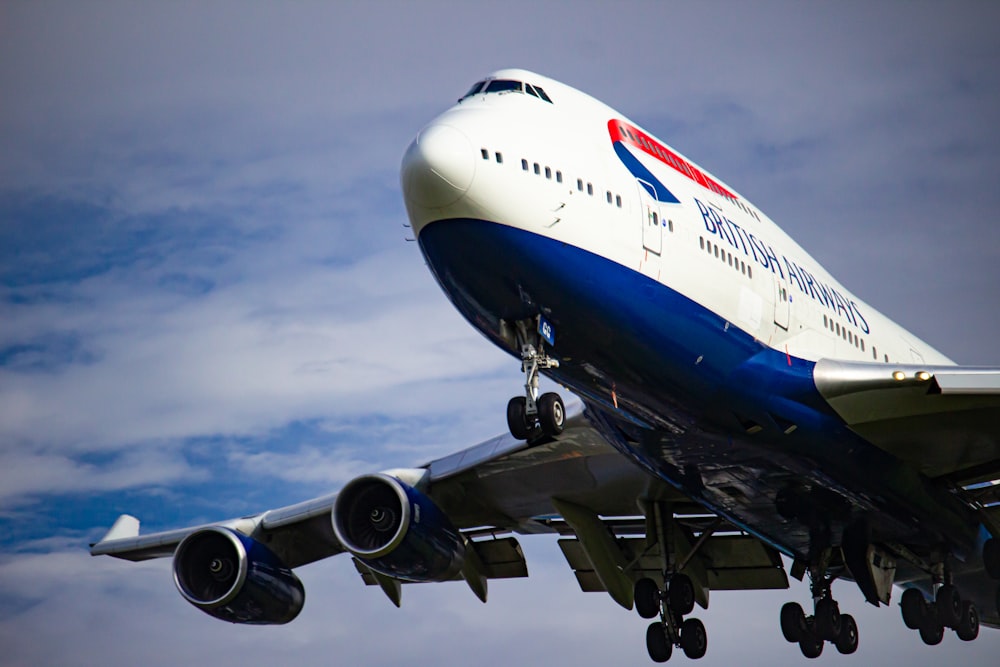 avión blanco y azul bajo nubes blancas durante el día