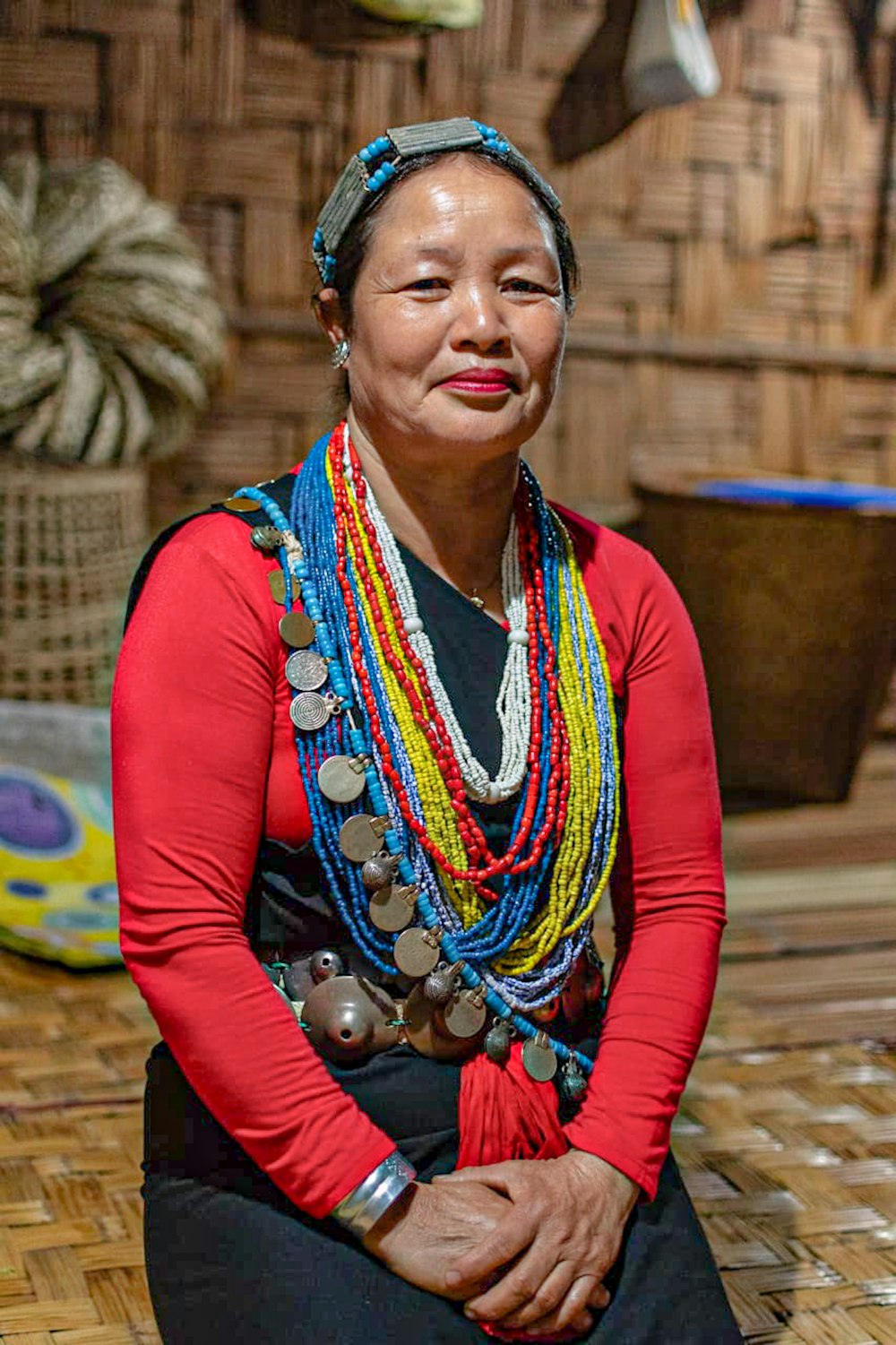 woman in red long sleeve shirt wearing blue and white beaded necklace