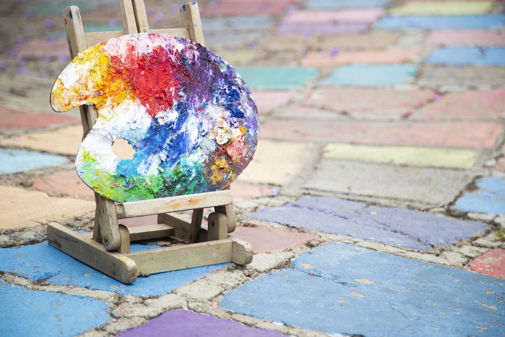 blue yellow and green floral globe on brown wooden stand