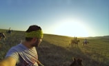 A group of travelers riding horses at sunset amidst the Andean mountains