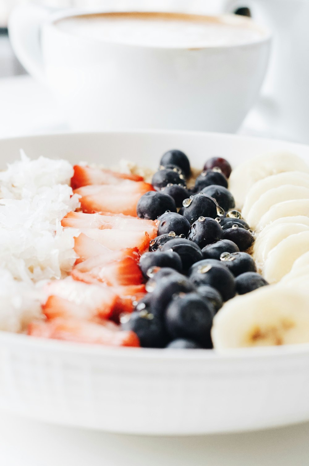 white cream with black berries on white ceramic bowl