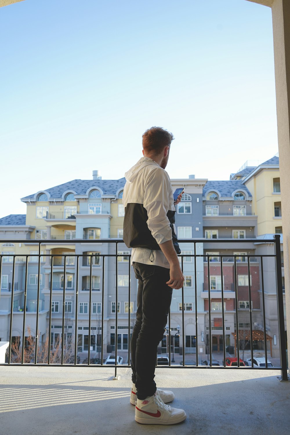 man in white dress shirt and black pants standing on top of building during daytime