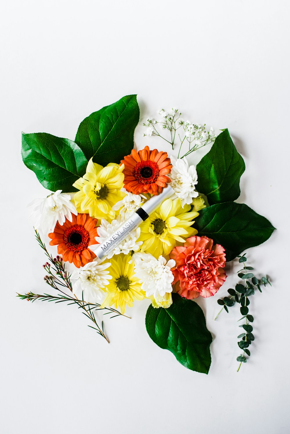 a bouquet of flowers and a syosher on a white surface