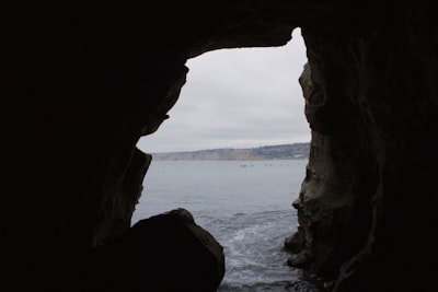 brown rock formation near body of water during daytime coast google meet background