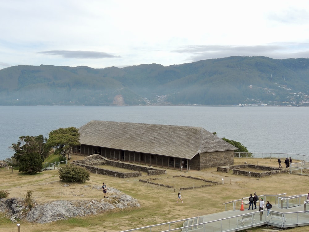 brown wooden house near body of water during daytime