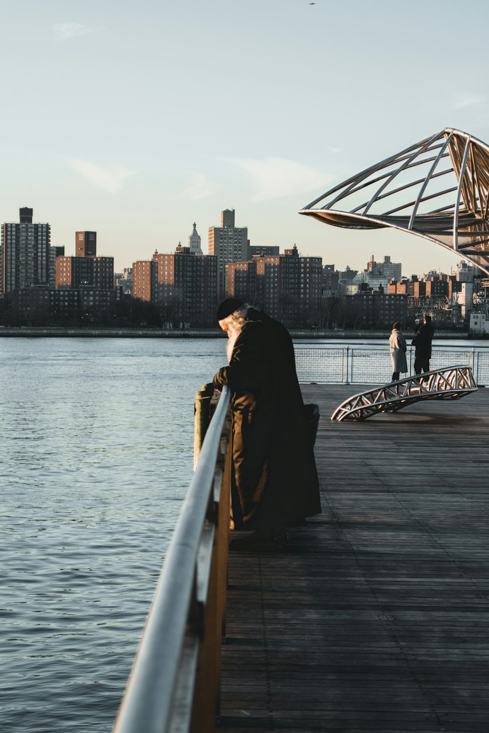 homme en veste noire debout sur le quai pendant la journée