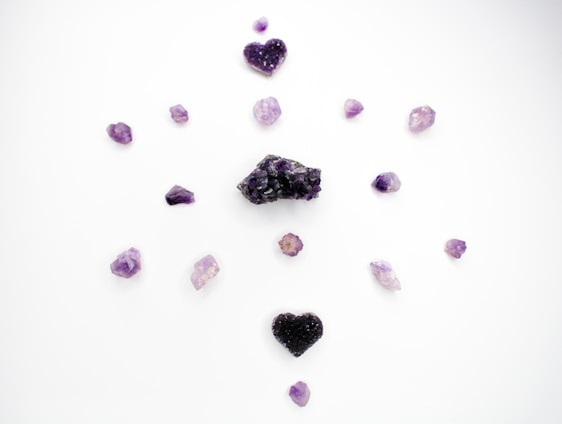 A serene arrangement of golden and purple healing crystals glowing softly against a dark background.