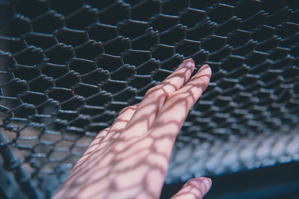 persons feet on black metal mesh net