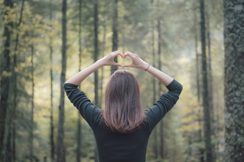 woman in black long sleeve shirt raising her hands