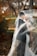 A romantic scene features a bride and groom embracing under a flowing veil in an outdoor setting. The bride holds a bouquet with autumnal colors, and fallen leaves cover the ground, creating a warm and intimate atmosphere.
