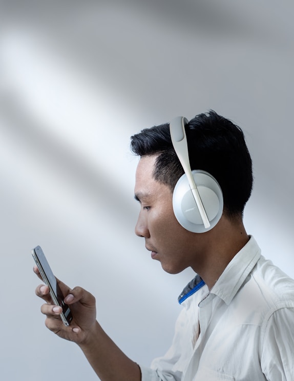 man in white dress shirt holding smartphone