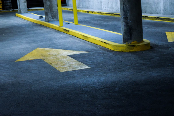 Yellow corner guards protecting the edges of a parking garage wall from vehicle damage.