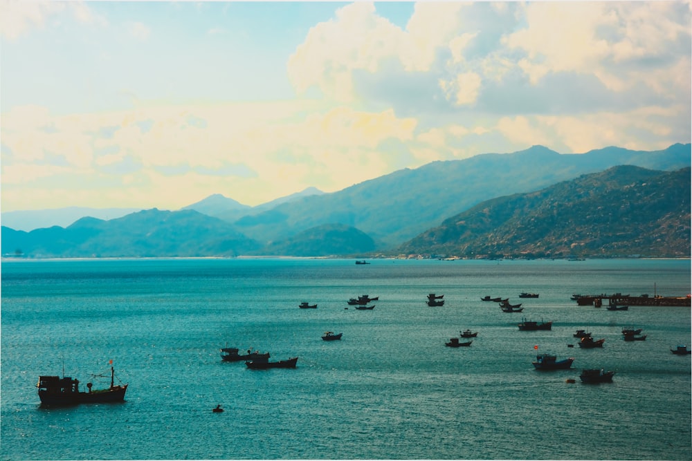 boats on sea near mountain during daytime