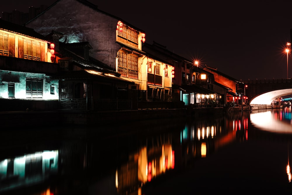 brown and white concrete building near body of water during night time