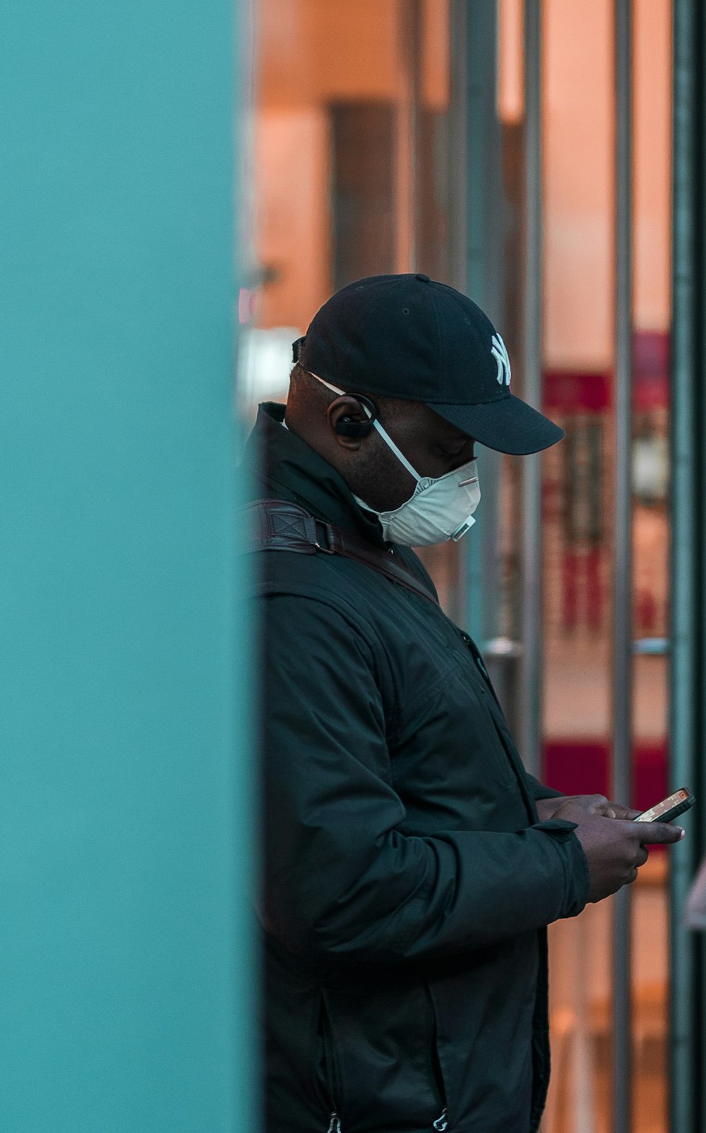 man in black jacket wearing white mask and black cap