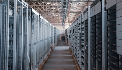 Rows of bitcoin mining machines operating in a well-ventilated mining farm.