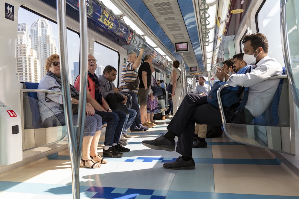 青と白の電車の座席に座る人々
