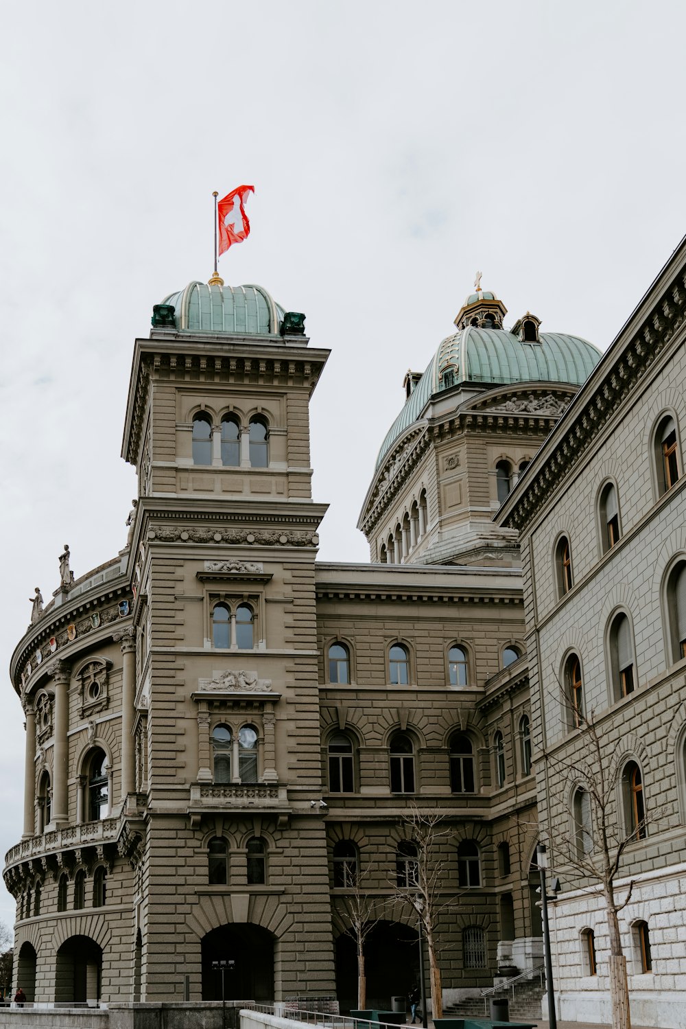 brown concrete building with flag on top during daytime