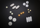 white and orange medication pill on black surface