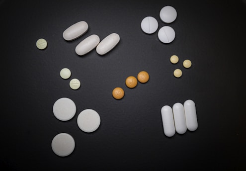 white and orange medication pill on black surface