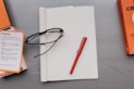 black framed eyeglasses on white paper