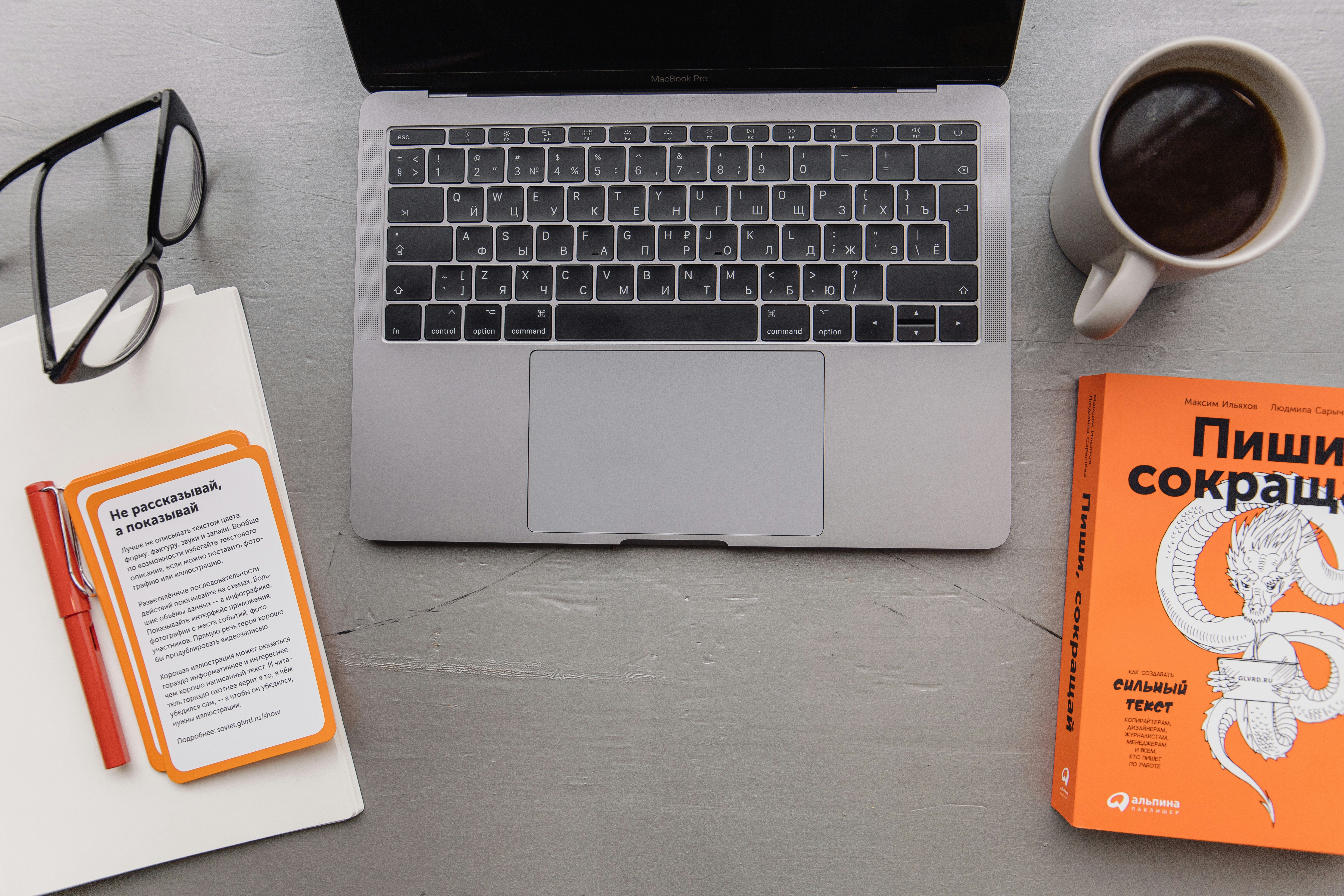 macbook pro beside white ceramic mug on white table