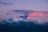 snow covered mountain under gray sky