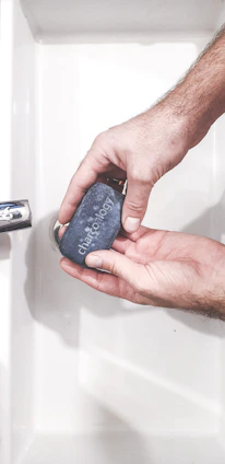 Close-up of a sleek acrylic soap dish holding a bar of soap beside a modern sink.