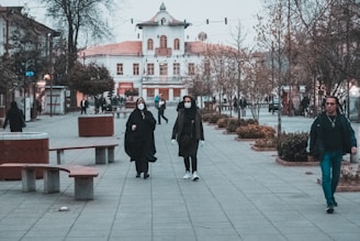 man in black coat standing on gray concrete floor during daytime