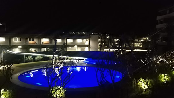 Night view of a pool illuminated by Authome reflectors with vibrant colors