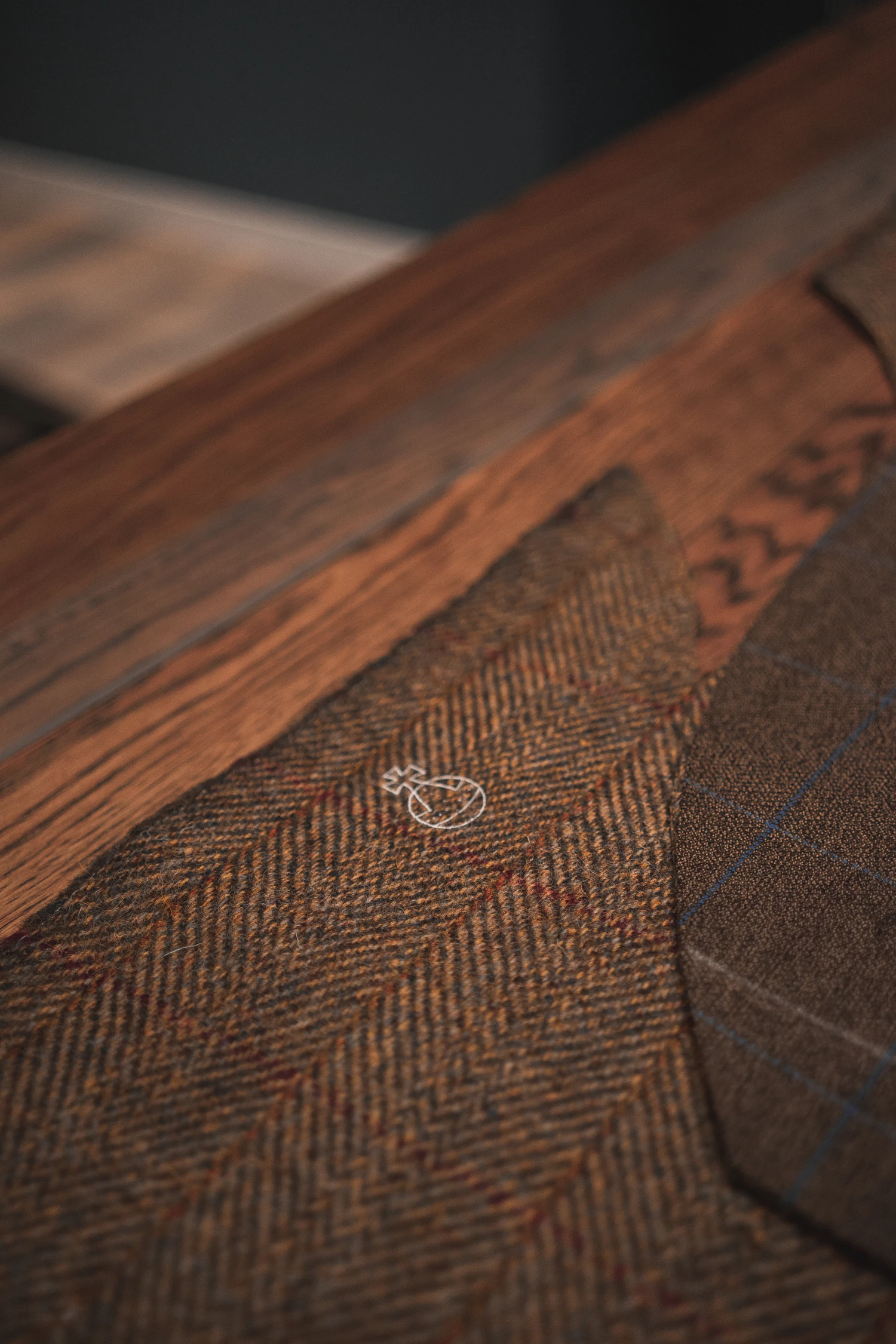 The Allendale ulster folded on the bench in camel herringbone, collar turned to show the weave