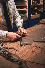 person in black suit holding brown leather bag