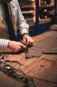 person in black suit holding brown leather bag