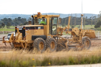 yellow and black heavy equipment on brown field during daytime