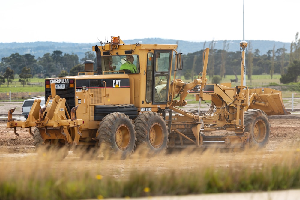 yellow and black heavy equipment on brown field during daytime